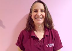 A photograph of one of our physiotherapists in front of our pink wall.