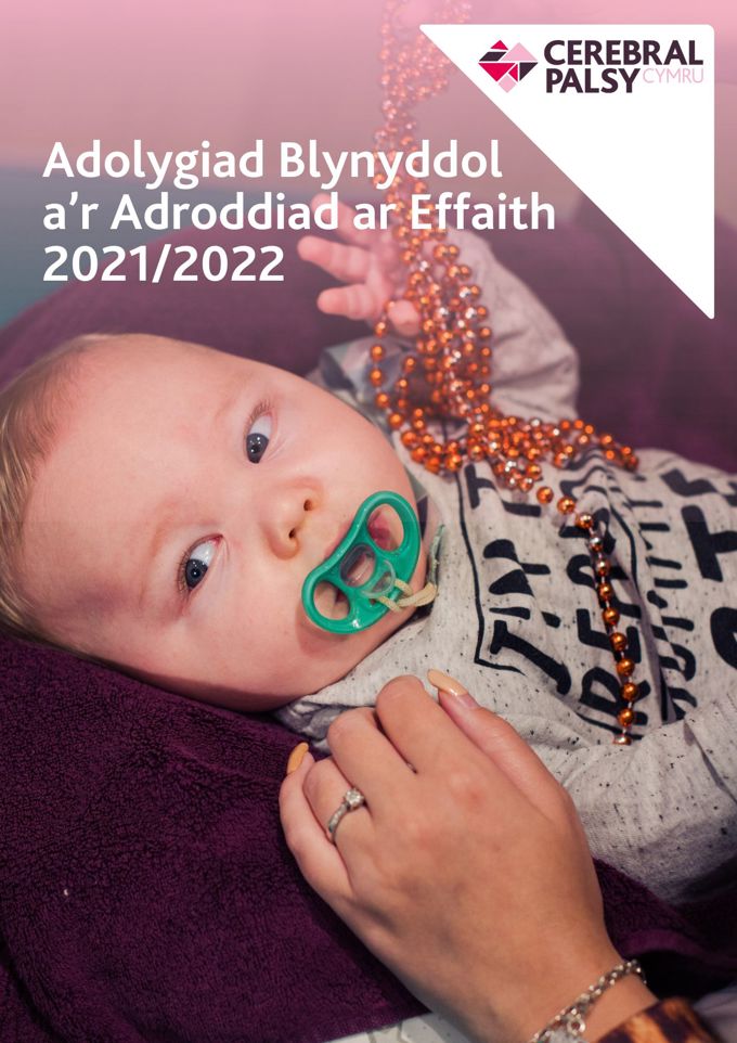 Screenshot of Welsh language Annual Review 2021/2022. Text reads 'Adolygiad blynyddol a'r Adroddiad ar Effaith 2021/2022'. Photograph shows young boy with dummy, reaching up towards some beads.