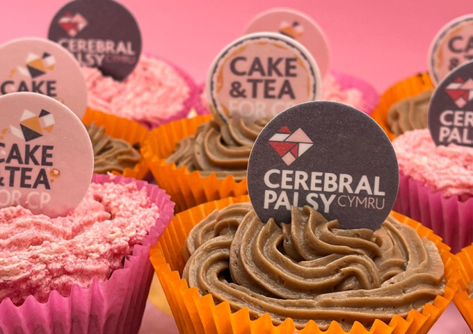 Photograph of cupcakes with Cerebral Palsy Cymru cake toppers on them.